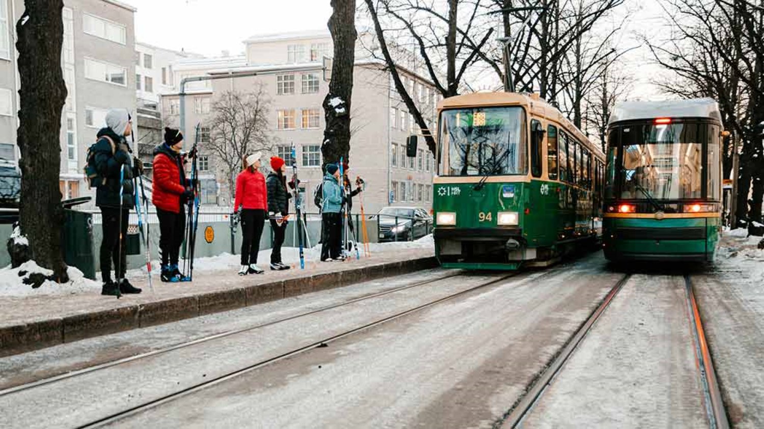 Ihmiset odottavat ratikkaa suksien kanssa