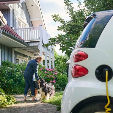 Sähköauto on latauksessa omakotitalon pihalla