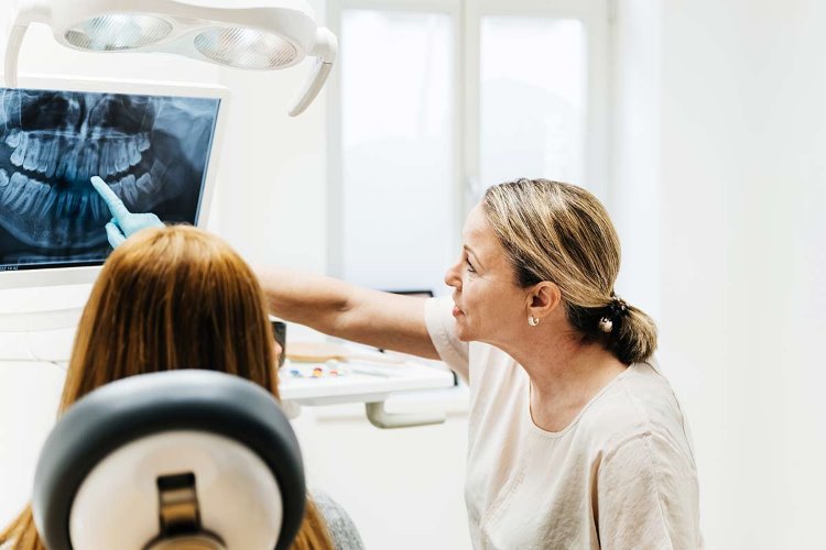 Hammaslääkäri tutkii röntgenkuvaa