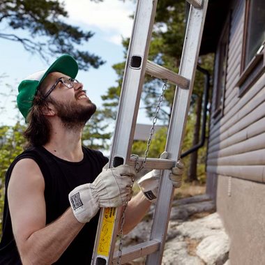 Mies pitelee tikkaita mökin reunalla